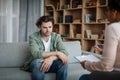 Despaired depressed young caucasian man suffers from mental problems, listens to black female psychologist Royalty Free Stock Photo