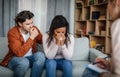 Despaired sad young european man calms black crying woman at meeting with psychologist in office