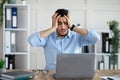 Desperate Arab businessman having too much work, making mistake, cannot meet deadline, suffering from headache at work Royalty Free Stock Photo