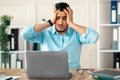Desperate Arab businessman having too much work, making mistake, cannot meet deadline, suffering from headache at work Royalty Free Stock Photo