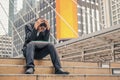 Desperate asian businessman with hands on head sitting on concrete stairs in urban city area. Royalty Free Stock Photo