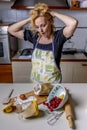 Desperate housewife with hands in her hair for the mess in the kitchen, which she will have to clean up