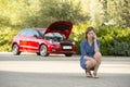 Desperate confused woman stranded with broken car engine crash accident calling on mobile phone Royalty Free Stock Photo