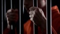 Desperate criminal holding jail bars feeling regret for committing crime closeup Royalty Free Stock Photo