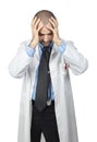Desperate doctor holds his head in his hands, wears a white coat