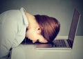 Desperate employee stressed woman resting head on laptop keyboard