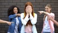 Desperate female teenager covering face by hands suffering school bullying