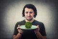 Desperate man crying as has only a lettuce batavia salad on dish plate. Dissatisfied vegan guy weeping as has little food to eat.