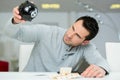 Desperate man holding piggy bank upside down Royalty Free Stock Photo