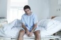 Desperate man at hospital bed alone sad and devastated suffering depression _ Royalty Free Stock Photo