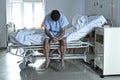 Desperate man sitting at hospital bed alone sad and devastated s Royalty Free Stock Photo