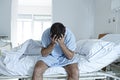 Desperate man sitting at hospital bed alone sad and devastated sick in clinic Royalty Free Stock Photo