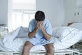 Desperate man sitting at hospital bed alone sad and devastated sick in clinic Royalty Free Stock Photo