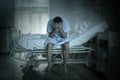 Desperate man sitting at hospital bed alone sad and devastated suffering depression crying at clinic Royalty Free Stock Photo