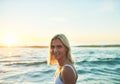 In desperate need of vitamin sea. Cropped portrait of an attractive young female smiling over her shoulder on the beach Royalty Free Stock Photo