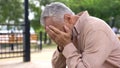 Desperate pensioner crying, covering eyes by hands, suffering loss, problem