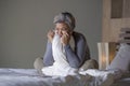 Dramatic lifestyle home portrait of attractive sad and depressed middle aged woman with grey hair on bed feeling upset suffering Royalty Free Stock Photo