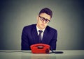 Desperate sad young business man waiting for someone to call him Royalty Free Stock Photo