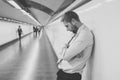 Desperate sad young businessman suffering emotional pain grief and deep depression sitting alone in tunnel subway in Stress life