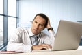 Desperate senior businessman in crisis working on computer laptop at office desk in stress under pressure