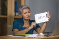 Desperate and stressed attractive middle aged Asian woman holding notepad asking for help feeling overworked and exploited working Royalty Free Stock Photo