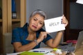 Desperate and stressed attractive middle aged Asian woman holding notepad asking for help feeling overworked and exploited working Royalty Free Stock Photo