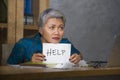 Desperate and stressed attractive middle aged Asian woman holding notepad asking for help feeling overworked and exploited working Royalty Free Stock Photo