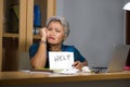 Desperate and stressed attractive middle aged Asian woman holding notepad asking for help feeling overworked and exploited working Royalty Free Stock Photo