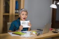 Desperate and stressed attractive middle aged Asian woman holding notepad asking for help feeling overworked and exploited working Royalty Free Stock Photo