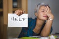 Desperate and stressed attractive middle aged Asian woman holding notepad asking for help feeling overworked and exploited working Royalty Free Stock Photo