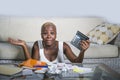 Desperate and stressed black afro American woman with calculator and paperwork banking in stress accounting business finance tax a Royalty Free Stock Photo