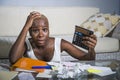 Desperate and stressed black afro American woman with calculator and paperwork banking in stress accounting business finance tax a Royalty Free Stock Photo