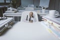 Desperate tiny businessman sitting at desk