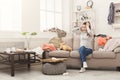 Desperate woman sitting on sofa in messy room Royalty Free Stock Photo