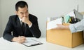 Desperately fired female office worker employee hands her employer her resignation letter and packs her belongings in a cardboard Royalty Free Stock Photo