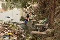 Dirty Laundry: Washerman wash clothes in polluted water Royalty Free Stock Photo