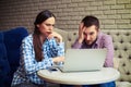 Despondent couple looking at laptop