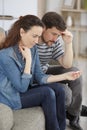 despondent couple looking at pregnancy test