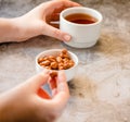 Dessert bars made of sunflower seeds  in a honey caramel. Caramelized peanuts in white bowl and on gray background..The process of Royalty Free Stock Photo