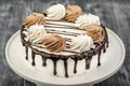 Dessert biscuit cake with white cream, whipped cream and chocolate glaze