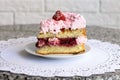 Dessert biscuit cake with strawberry jam, whipped cream and fresh strawberries on a white napkin