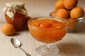 Dessert bowl with delicious apricot jam and spoon on white wooden table Royalty Free Stock Photo