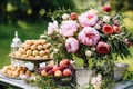 Dessert buffet with peony flowers, catering for wedding, party and holiday celebration, cakes and desserts in a countryside garden