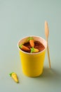 Dessert, carrot cake to go in a yellow paper cup, decorated with cocoa and marzipan carrots on a green plain background. Trendy Royalty Free Stock Photo