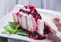 Dessert Cheesecake with Berries Sauce and green mint in plate on dark background
