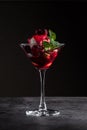 Dessert with Cherry Sauce, biscuits and mint in a martini glass on a black marble background Royalty Free Stock Photo