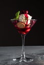 Dessert with Cherry Sauce, biscuits and mint in a martini glass on a grey table and black background Royalty Free Stock Photo