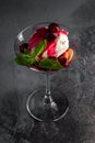 Dessert with Cherry Sauce, biscuits and mint in a martini glass on a grey table and black background. top view Royalty Free Stock Photo