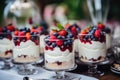 Dessert with fresh berries and whipped cream. Selective focus, Sweet tasty cakes with berries and cream on dessert table at