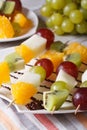 Dessert of fresh fruit on skewers close-up. Vertical Royalty Free Stock Photo